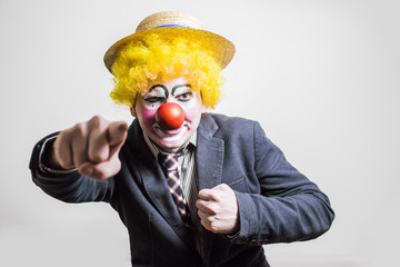 the clown shows his fingers in front of dressed as a businessman