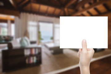 hand holding blank paper with interior background