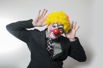 the clown joyfully waving his hands in greeting dressed as a businessman