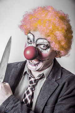 scary clown with a knife in his hand