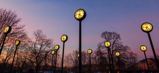 Bahnhofsuhren in einem Park in Düsseldorf nach Sonnenuntergang © Christian Müller
