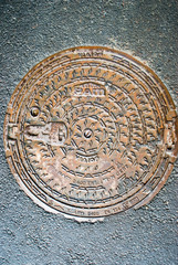 Old manhole cover on asphalt in Kaliningrad, Russia