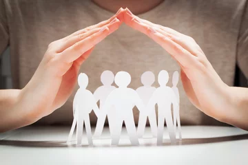 Fotobehang Paper people under hands in gesture of protection.. Concept of insurance © Photocreo Bednarek