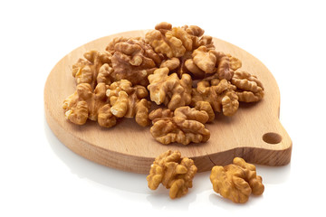 Walnuts on wooden board. Isolated on white background.