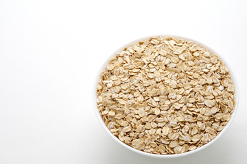 Oat flakes in a bowl. Oatmeal day.