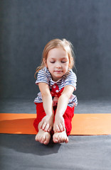 Kid doing fitness yoga exercises