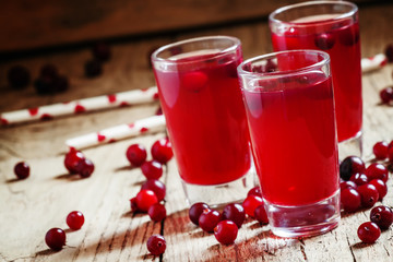 Red cocktail with natural cranberry juice and vodka, old wooden