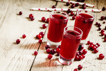 Red cocktail with natural cranberry juice and vodka, old wooden