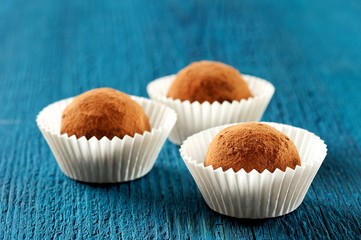 Set of round homemade vegan truffles in crimped paper plates on