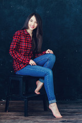 Fototapeta na wymiar beautiful girl sitting on a chair in photo studio