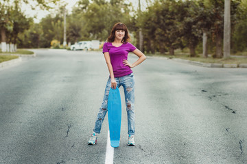 a girl standing with skateboard outdoors
