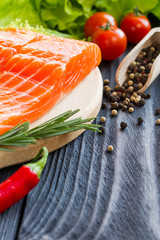 Fresh raw salmon fillet on cutting board.
