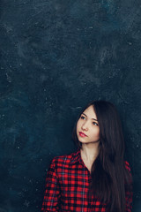 Fototapeta premium beautiful girl stands near the wall in the Studio