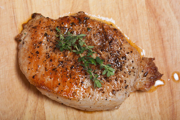 Fresh fried meat with thyme, garlic and cucumber on light wooden