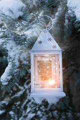 Little winter lantern hanging outdoors on a Christmas tree under