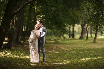 Fototapeta premium Bride and groom walking away in summer park outdoors