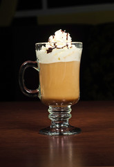 Fragrant coffee with chocolate and whipped cream cap on a dark background