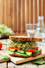 sprouts avocado tomato spinach chickpeas burger rye sandwich