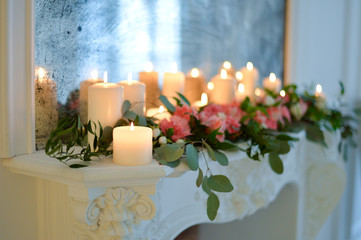 Candles and branches on fireplace