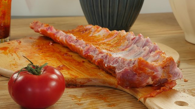 Preparing BBQ spicy marinated and smoked pork spareribs 