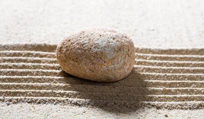 Fototapeta na wymiar zen sand still-life - textured pebble on straight lines for concept of wisdom or simplicity