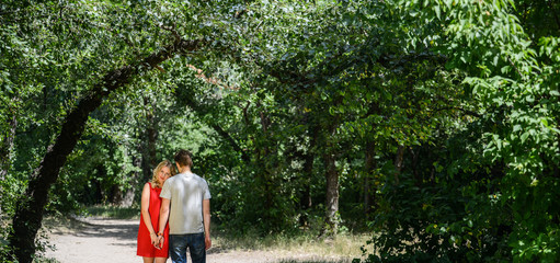 young pretty couple in the green summer park