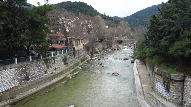 Kosynthos river water running by the city of Xanthi, Greece on a cloudy day (wide shot)