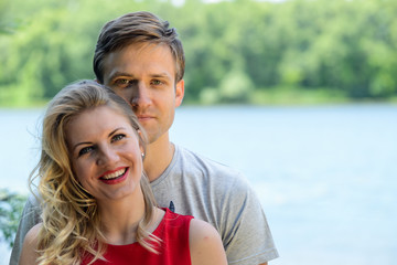 Young happy couple hugging and laughing on river background