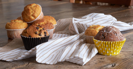 Several different muffins on a wooden table.