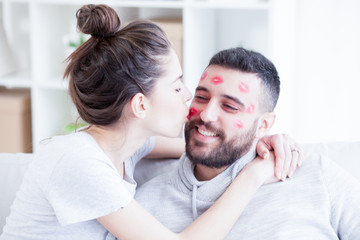 Fototapeta premium Woman kissing man with red lipstick all over his face,shallow depth of field