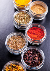 Obraz na płótnie Canvas Spices on black background in special jars. Food