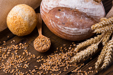 Assortment of baked bread on wooden table background