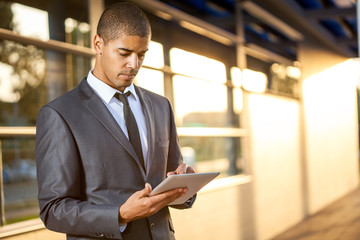 Successful business man with digital tablet outside