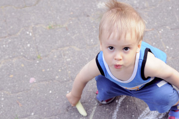 Fototapeta premium Boy drawing with a chalk on asfalt