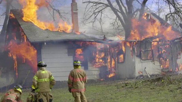 Firefighters watch as a house burns to the ground 
