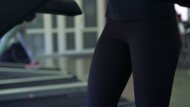 Close-up of girl's legs in the gym on the treadmill