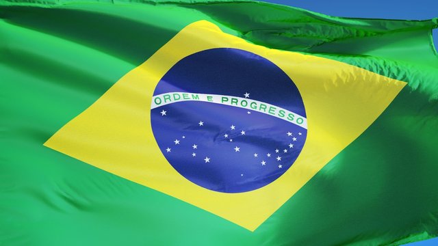 Brazil flag waving in slow motion against clean blue sky, seamlessly looped, close up, isolated on alpha channel with black and white luminance matte, perfect for film, news, digital composition