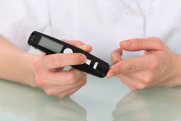 Patient Hand Checking Blood Sugar Level With Glucometer