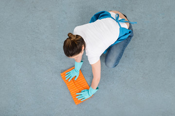 Female Janitor Mopping Floor With Duster