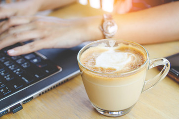 coffee cup on wood table with labtop office space