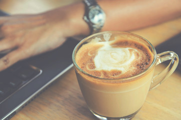 coffee cup on wood table with labtop office space