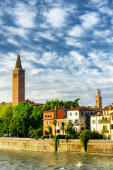 Fototapeta premium Houses on Adige waterfront and bell tower of church, Verona