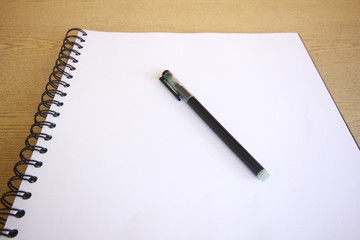 notebook with pen on wooden table