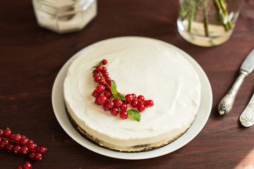 yoghurt cake with currants on wooden background
