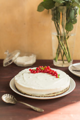 yoghurt cake with currants on wooden background