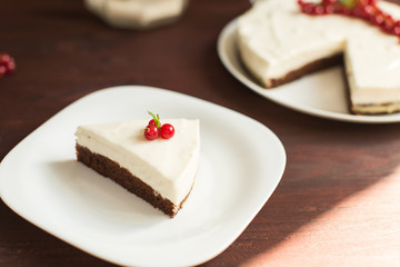 yoghurt cheesecake with fresh red currants on wooden table