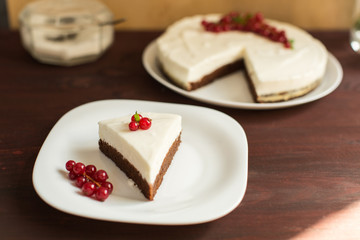 yoghurt cheesecake with fresh red currants on wooden table