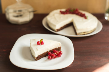 yoghurt cheesecake with fresh red currants on wooden table