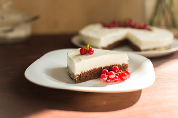 yoghurt cheesecake with fresh red currants on wooden table