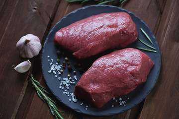 Basalt plate with fresh uncooked asado steaks, studio shot